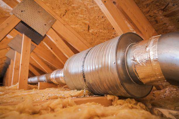Attic ventilation ducting installed in a wooden framework, surrounded by insulation, highlighting energy efficiency solutions for homes.