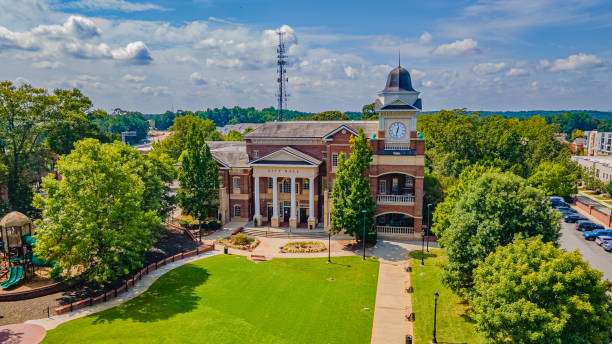Buford City Hall building with clock tower surrounded by greenery and park area, representing community and local governance in Buford, Georgia.