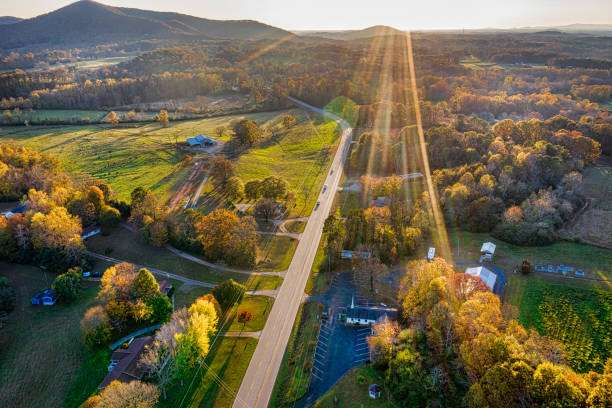 Aerial view of a scenic road in Cleveland, GA, surrounded by vibrant autumn foliage and rolling hills, showcasing the area's natural beauty and rural charm.