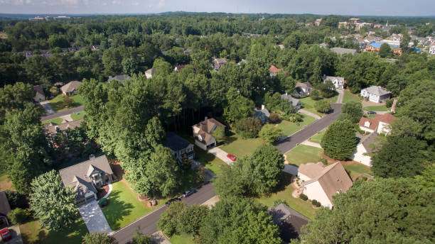 Aerial view of residential neighborhood in Cumming, GA, showcasing tree-lined streets, diverse home styles, and well-maintained yards, reflecting the community's family-friendly environment and potential for home remodeling and construction projects.