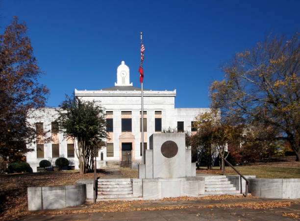 Historic courthouse building in Gainesville, GA, featuring a flagpole with American flag, surrounded by trees and autumn leaves, representing local heritage and community.
