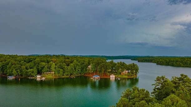 Aerial view of Lake Oconee showcasing lush greenery, serene waters, and lakeside homes, emphasizing the tranquil outdoor lifestyle ideal for custom builds and renovations by Artisan Roofing & Construction.