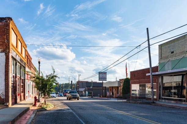 Street view of Statham, GA, featuring local businesses, a clear sky, and vehicles, highlighting the community's charm and accessibility for homeowners seeking roofing and remodeling services.