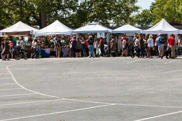 Crowd of people at outdoor market with vendor tents, showcasing local crafts and goods in Braselton, GA.
