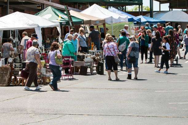 Crowd of people browsing stalls at a vibrant outdoor market in Braselton, GA, showcasing various handmade crafts and local goods.