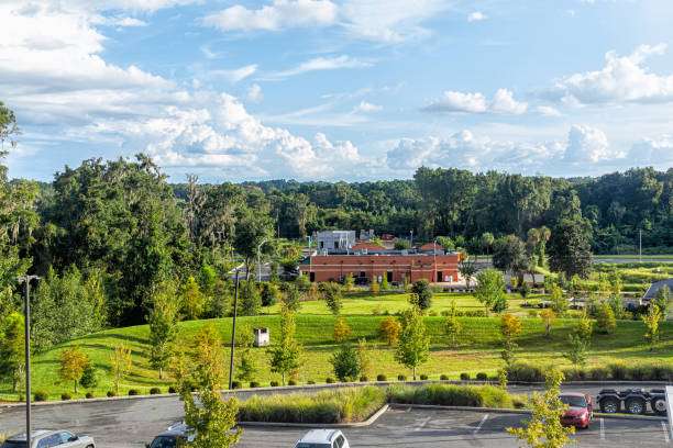Scenic view of Gainesville, GA, featuring green park space, trees, and a building, highlighting the community's blend of nature and urban development.
