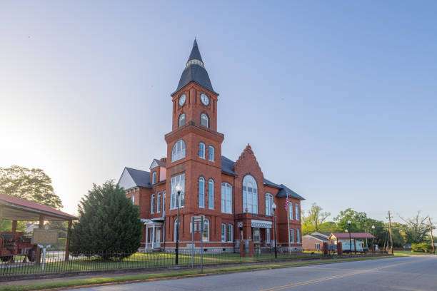 Historic red brick building with clock tower in Statham, GA, representing community heritage and local architecture.