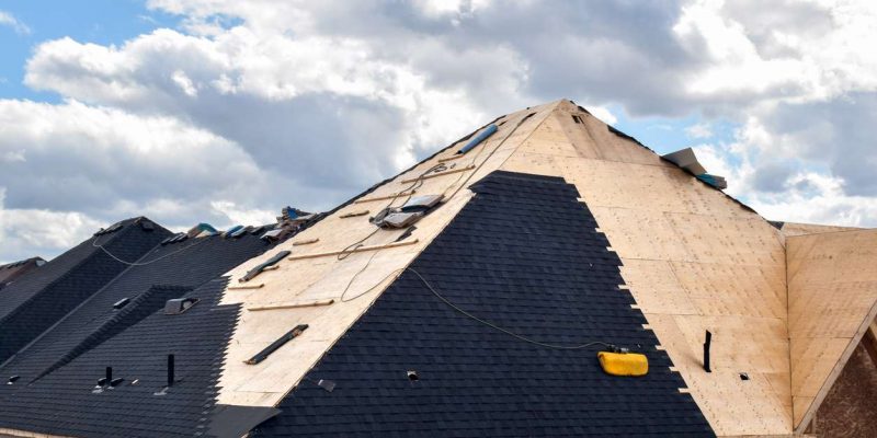 The process of installation of black roof shingles on new residential home